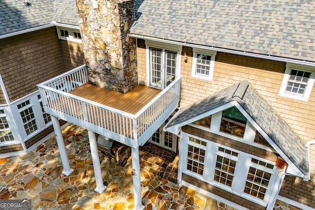 rear view of house featuring a shingled roof, stairway, a patio area, and a wooden deck