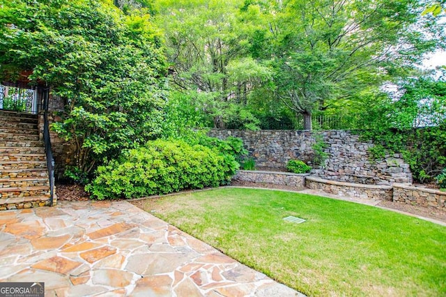 view of green lawn featuring a patio and stairs
