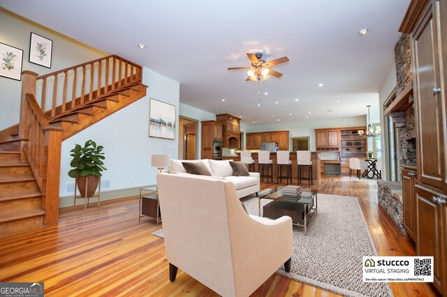 living area with ceiling fan, stairs, light wood-style floors, and recessed lighting