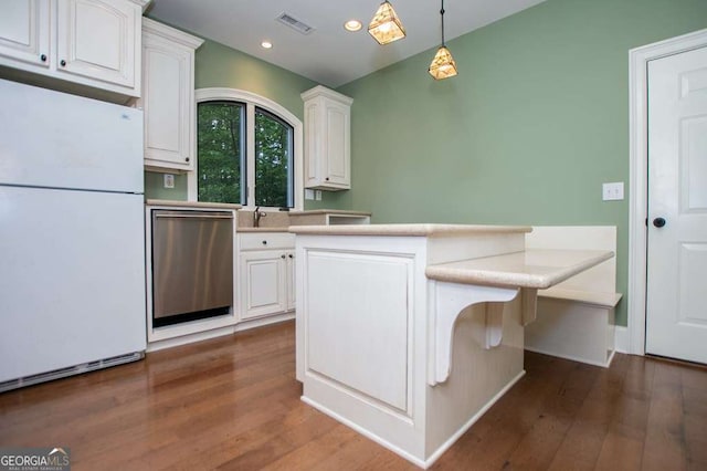 kitchen featuring freestanding refrigerator, dishwasher, white cabinetry, dark wood-style floors, and hanging light fixtures