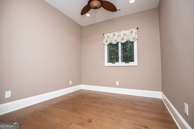 spare room with a ceiling fan, baseboards, wood finished floors, and recessed lighting