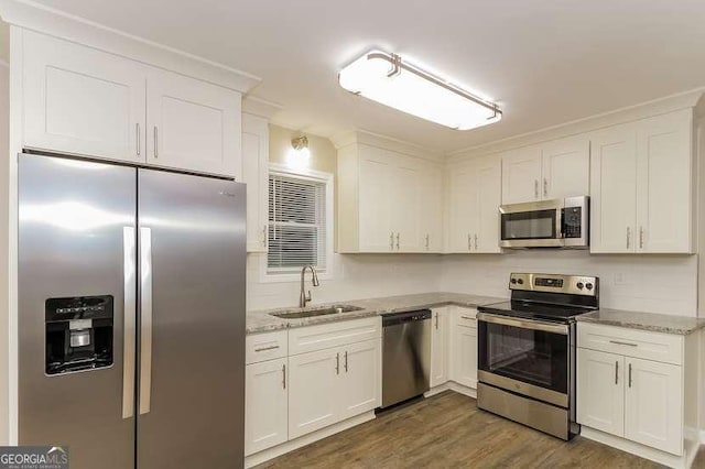 434 Mona Pl, Dallas, GA 30132 - kitchen with appliances with stainless steel finishes, a sink, white cabinets, wood finished floors, and light stone counters
