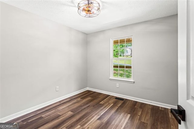 86 Williams Rd, Dallas, GA 30132 - empty room featuring dark wood-type flooring, baseboards, and a textured ceiling