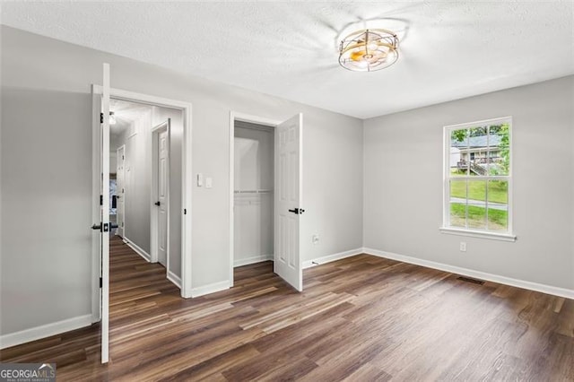 86 Williams Rd, Dallas, GA 30132 - unfurnished bedroom with wood finished floors, a closet, baseboards, and a textured ceiling