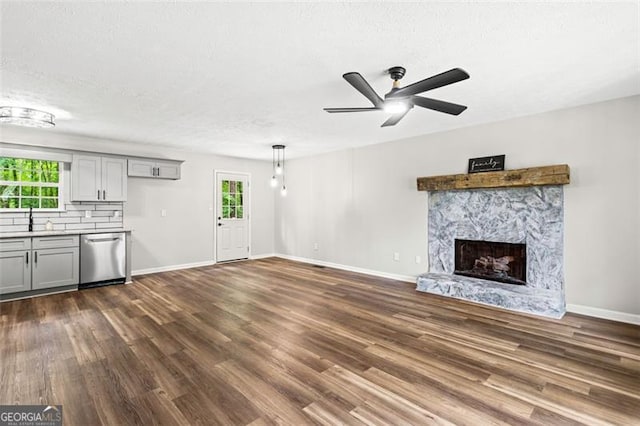 86 Williams Rd, Dallas, GA 30132 - unfurnished living room featuring dark wood finished floors, plenty of natural light, a ceiling fan, and a textured ceiling