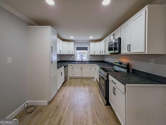 136 Oak St Unit 0, Omega, GA 31775 - kitchen with appliances with stainless steel finishes, dark countertops, light wood-style flooring, white cabinetry, and recessed lighting