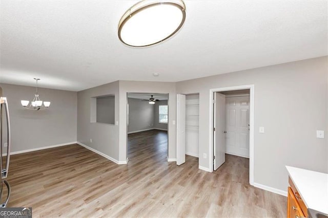 1023 Saint Augustine Pkwy, Locust Grove, GA 30248 - unfurnished dining area featuring light wood-style floors, baseboards, a chandelier, and ceiling fan