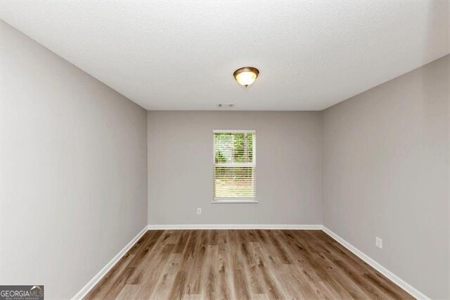 1023 Saint Augustine Pkwy, Locust Grove, GA 30248 - empty room with wood finished floors and baseboards
