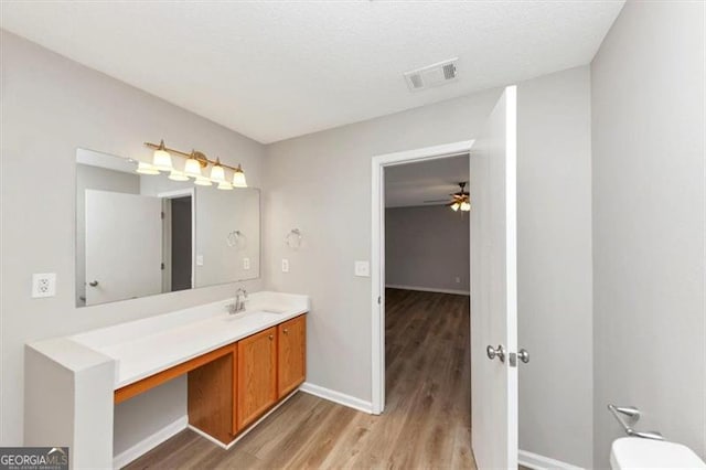 1023 Saint Augustine Pkwy, Locust Grove, GA 30248 - bathroom featuring wood finished floors, baseboards, ceiling fan, vanity, and toilet