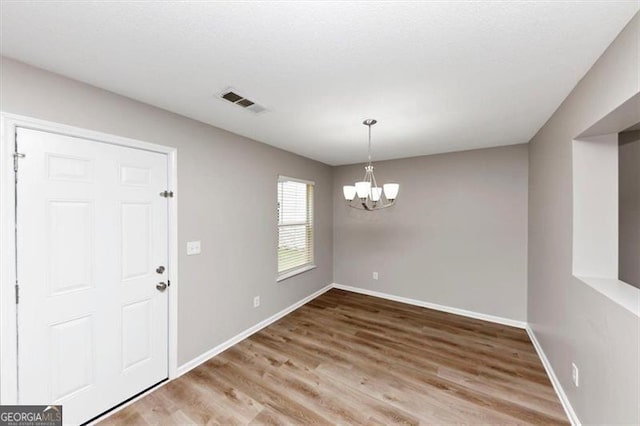 1023 Saint Augustine Pkwy, Locust Grove, GA 30248 - unfurnished dining area featuring a chandelier, wood finished floors, and baseboards