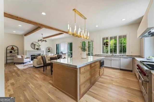 2000 Birmingham Rd, Milton, GA 30004 - kitchen with wall chimney range hood, dishwashing machine, double oven range, a fireplace, and plenty of natural light