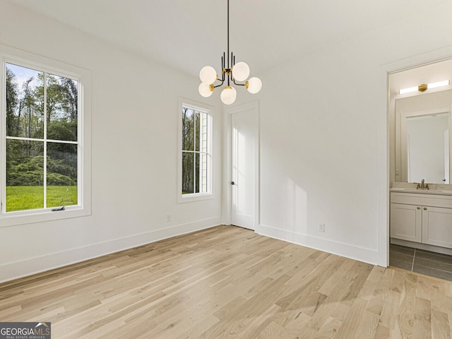 2000 Birmingham Rd, Milton, GA 30004 - unfurnished dining area featuring light wood-style flooring, a sink, a chandelier, and baseboards
