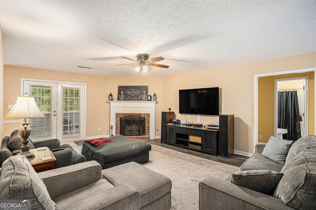 325 N Oakland Cir, Mcdonough, GA 30253 - living room with a ceiling fan, a brick fireplace, baseboards, and a textured ceiling