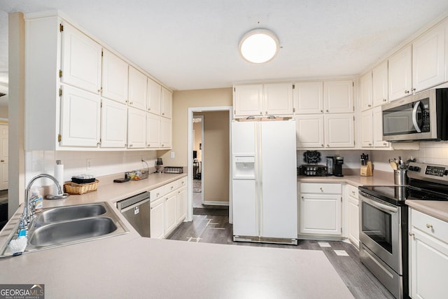 325 N Oakland Cir, Mcdonough, GA 30253 - kitchen with stainless steel appliances, a sink, wood finished floors, decorative backsplash, and light countertops