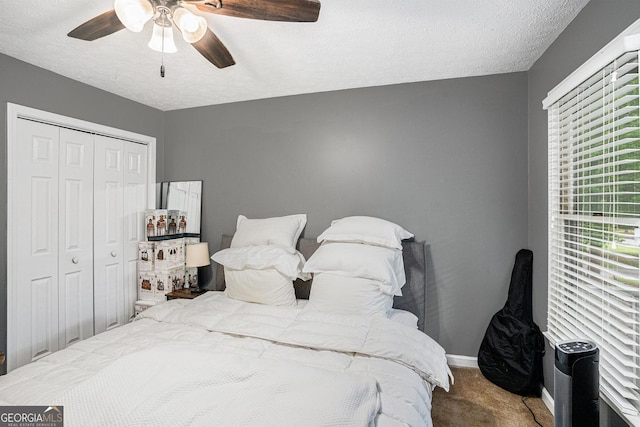 325 N Oakland Cir, Mcdonough, GA 30253 - carpeted bedroom with a closet, a ceiling fan, baseboards, and a textured ceiling