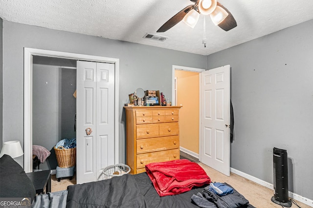 325 N Oakland Cir, Mcdonough, GA 30253 - bedroom with a closet, light carpet, baseboards, ceiling fan, and a textured ceiling