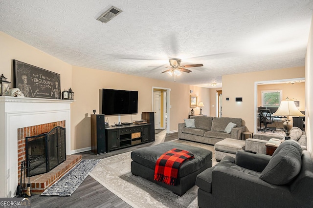 325 N Oakland Cir, Mcdonough, GA 30253 - living area with dark wood-style flooring, ceiling fan, a brick fireplace, a textured ceiling, and baseboards