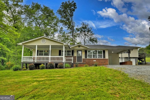 ranch-style house with a front yard, brick siding, gravel driveway, and covered porch