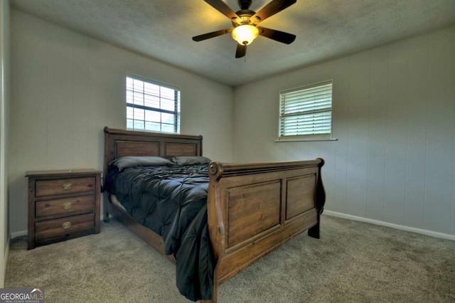 bedroom with multiple windows, carpet, baseboards, a textured ceiling, and a ceiling fan