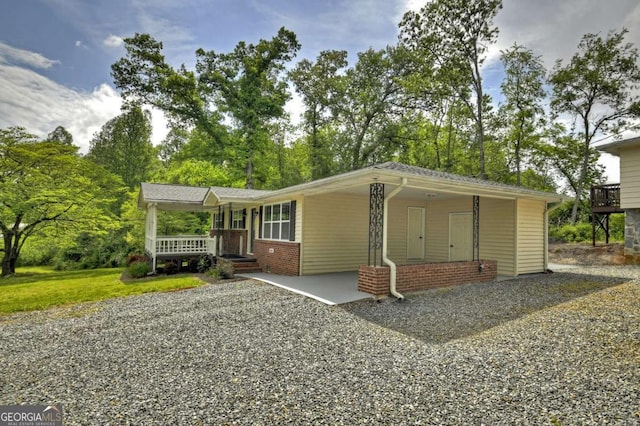 view of front of house featuring covered porch, brick siding, and a front lawn