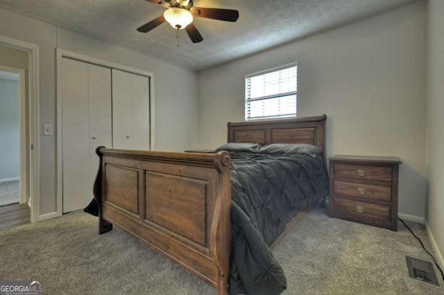bedroom with light colored carpet, a closet, a textured ceiling, ceiling fan, and baseboards