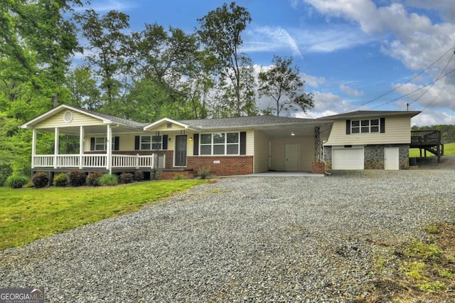 view of front of property with driveway, a porch, brick siding, a front lawn, and a garage