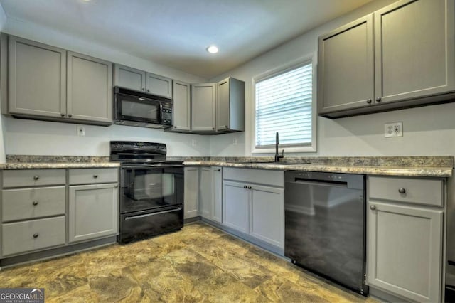 kitchen featuring black appliances, a sink, gray cabinets, and recessed lighting