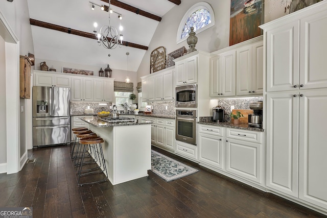 100 Rosemont, Peachtree City, GA 30269 - kitchen with appliances with stainless steel finishes, beamed ceiling, tasteful backsplash, a breakfast bar area, and white cabinetry