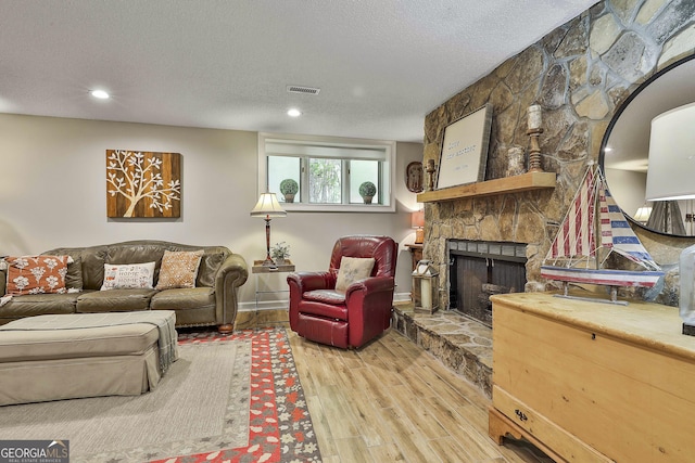 100 Rosemont, Peachtree City, GA 30269 - living room featuring wood finished floors, a stone fireplace, a textured ceiling, recessed lighting, and baseboards