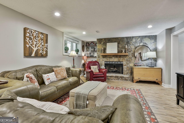 100 Rosemont, Peachtree City, GA 30269 - living area featuring wood finished floors, a textured ceiling, a stone fireplace, and recessed lighting