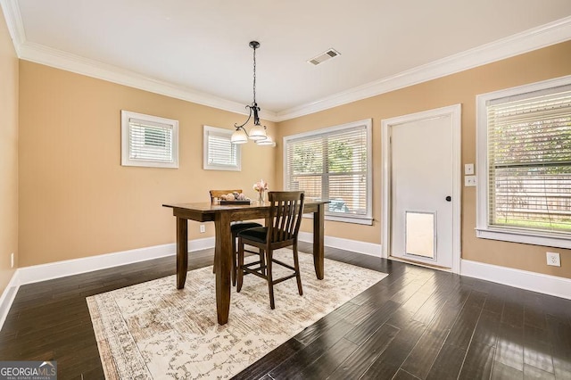 dining room with ornamental molding, baseboards, dark wood finished floors, and a chandelier