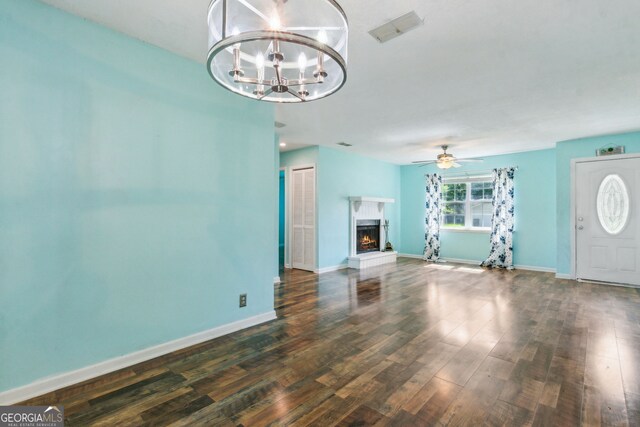 114 Pineneedle Ct, Kingsland, GA 31548 - unfurnished living room featuring wood finished floors, a chandelier, baseboards, a fireplace, and a ceiling fan