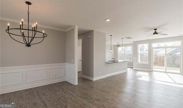 118 Grimsby Rd, Savannah, GA 31407 - unfurnished living room featuring wood finished floors, a chandelier, ceiling fan, crown molding, and a wainscoted wall