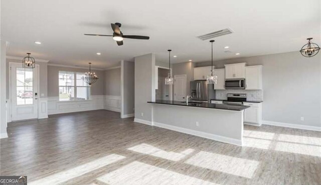 118 Grimsby Rd, Savannah, GA 31407 - kitchen featuring stainless steel appliances, a chandelier, light wood-type flooring, dark countertops, and open floor plan