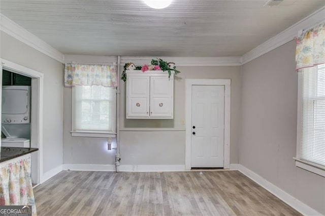 144 6th St, Monroe, GA 30655 - unfurnished dining area with stacked washer / dryer, ornamental molding, plenty of natural light, and light wood finished floors