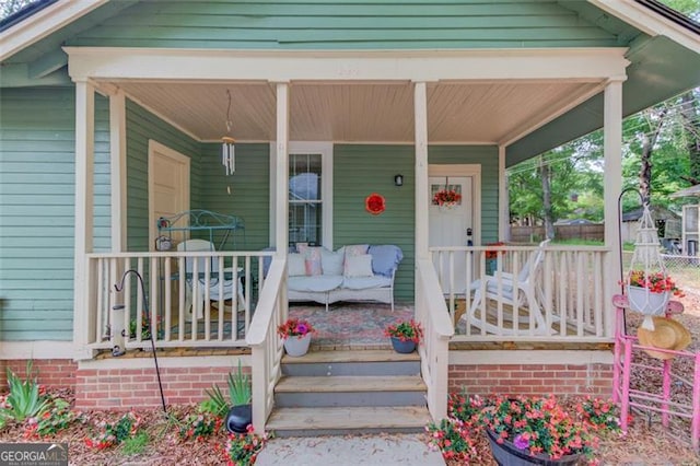 144 6th St, Monroe, GA 30655 - view of exterior entry with a porch and fence