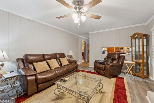 living room with wood finished floors, crown molding, and a ceiling fan