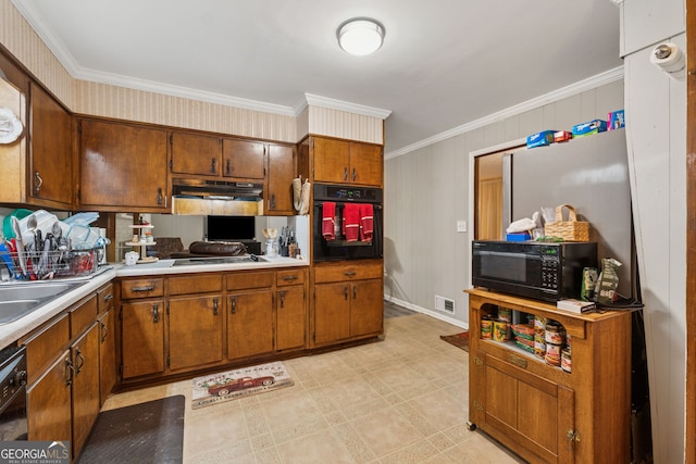 kitchen with black appliances, crown molding, under cabinet range hood, light countertops, and brown cabinetry