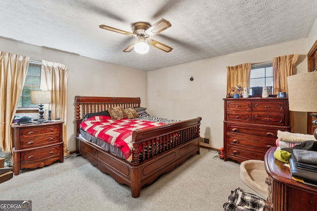 bedroom featuring carpet floors, ceiling fan, and a textured ceiling