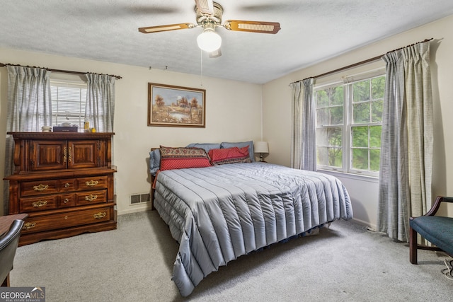 carpeted bedroom featuring baseboards, a textured ceiling, and a ceiling fan