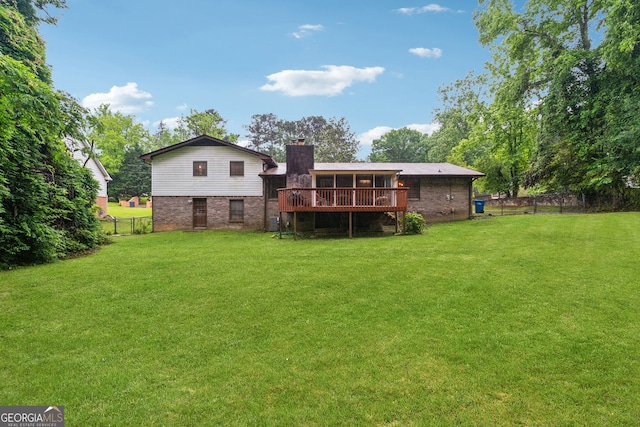 rear view of property with a chimney, brick siding, and a deck