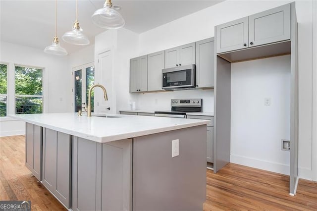 140 Racine St, Atlanta, GA 30314 - kitchen with appliances with stainless steel finishes, gray cabinetry, light wood finished floors, and light countertops