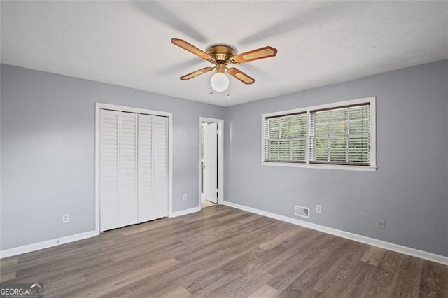 6997 Vesta Brook Dr, Morrow, GA 30260 - unfurnished bedroom featuring baseboards, wood finished floors, a closet, and a ceiling fan
