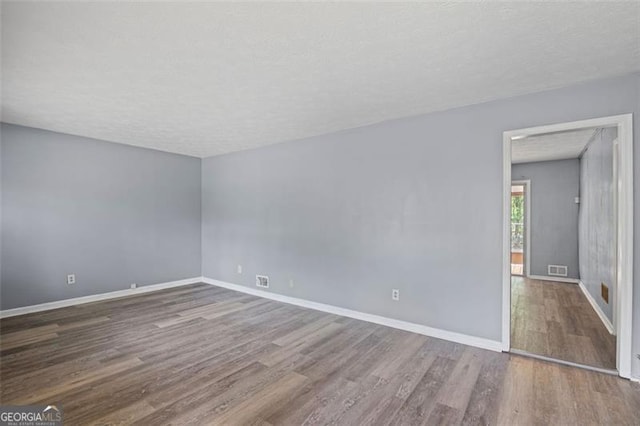 6997 Vesta Brook Dr, Morrow, GA 30260 - unfurnished room with wood finished floors, baseboards, and a textured ceiling