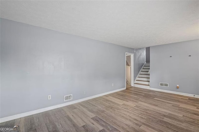 6997 Vesta Brook Dr, Morrow, GA 30260 - unfurnished living room with stairs, wood finished floors, baseboards, and a textured ceiling