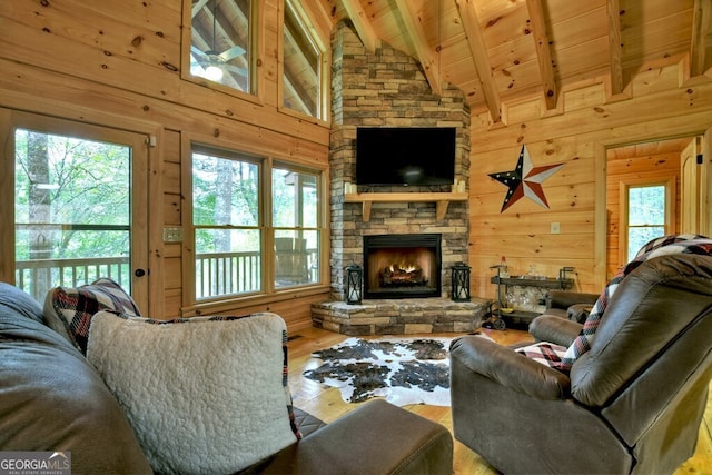 120 Christopher Dr, Ellijay, GA 30540 - living room featuring wood finished floors, wood walls, a wooden ceiling with exposed beams, plenty of natural light, and a stone fireplace