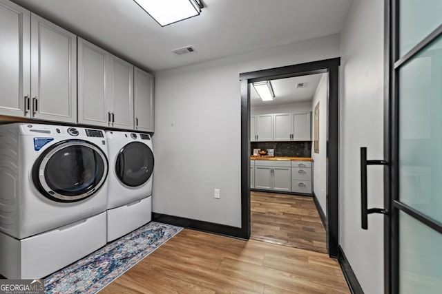 312 Charles Rd, Ellijay, GA 30540 - laundry room featuring independent washer and dryer, cabinet space, and light wood-type flooring