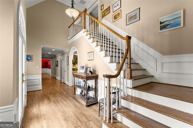 194 Sentinel Pl SE, Marietta, GA 30067 - staircase featuring a decorative wall, a high ceiling, wood finished floors, and wainscoting