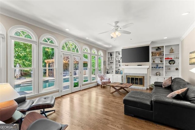 194 Sentinel Pl SE, Marietta, GA 30067 - living room with ornamental molding, plenty of natural light, ceiling fan, wood finished floors, and a tiled fireplace