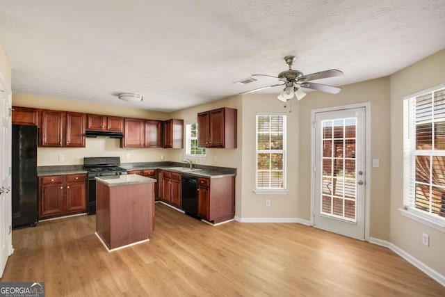 40 Wimberly Way, Covington, GA 30016 - kitchen featuring black appliances, light wood-type flooring, a kitchen island, ceiling fan, and a textured ceiling